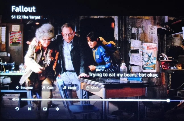 Episode frame from Season 1, Episode 2 showing the workshop set with the poster upper left